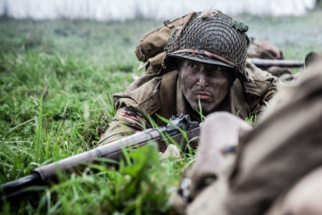 502nd PIR paratrooper takes cover from German machine gun nests near Carentan, France. (Dramatic Recreation) Elliot Wesley