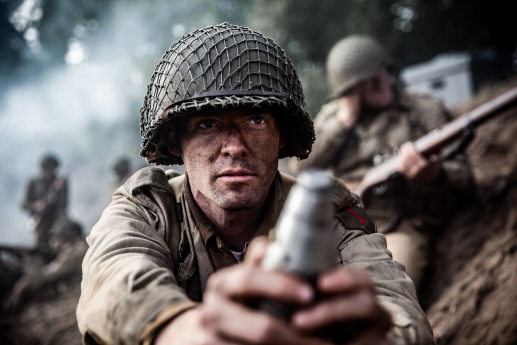 American soldier loads mortar rounds in attack on German held bunkers on Crucifix Hill. (Dramatic Recreation) William Grossman