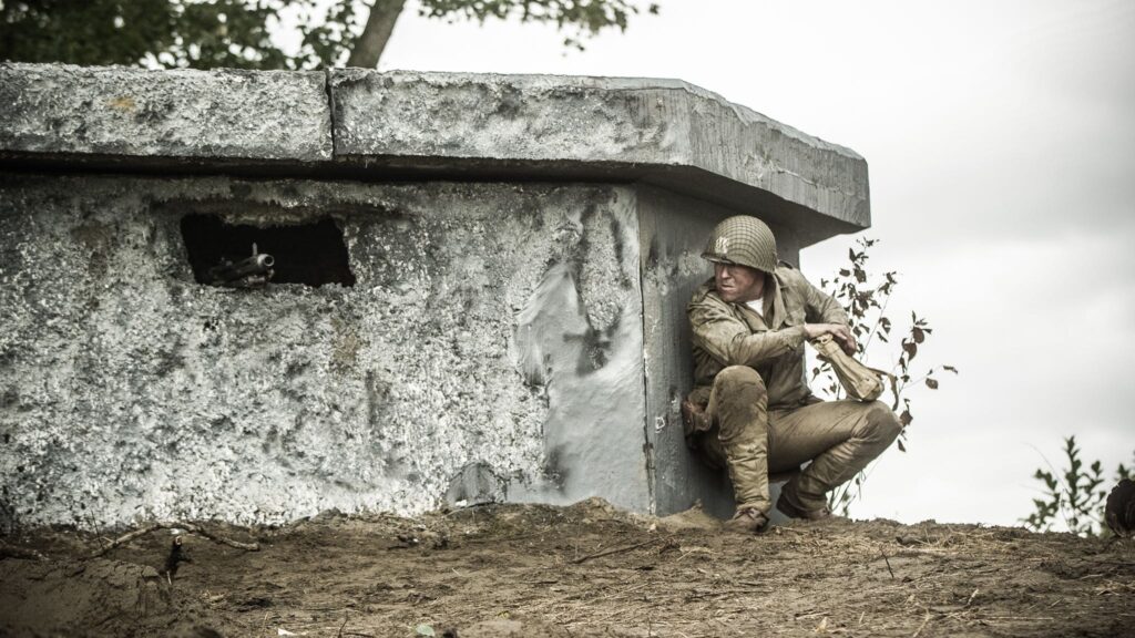 Captain Bobby Brown creeps in close enough to throw a satchel charge into a German operated Bunker on Crucifix Hill. (Dramatic Recreation) Jason Johnson