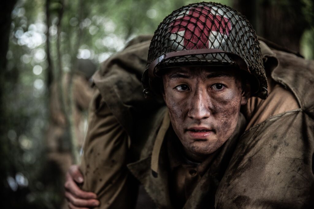 An American Medic carries a wounded soldier down from battle for medical aid. (Dramatic Recreation) Gabriel Prevost