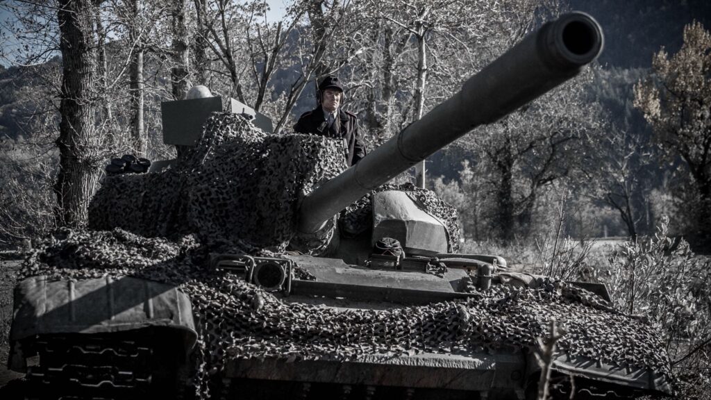 German tank commander stands in hatch as tank targets soldiers of the 442nd Regimental Combat Team in Vosges Mountain, France. (Dramatic Recreation) Mark Masterton