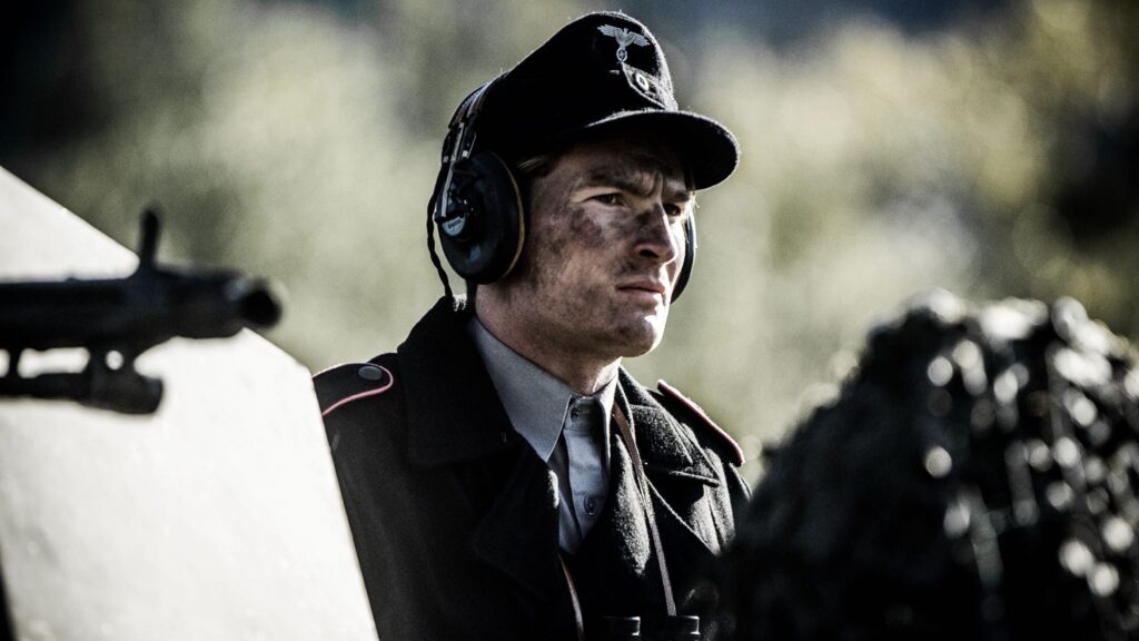 German tank commander stands in hatch as tank targets soldiers of the 442nd Regimental Combat Team in Vosges Mountain, France. (Dramatic Recreation) Mark Masterton