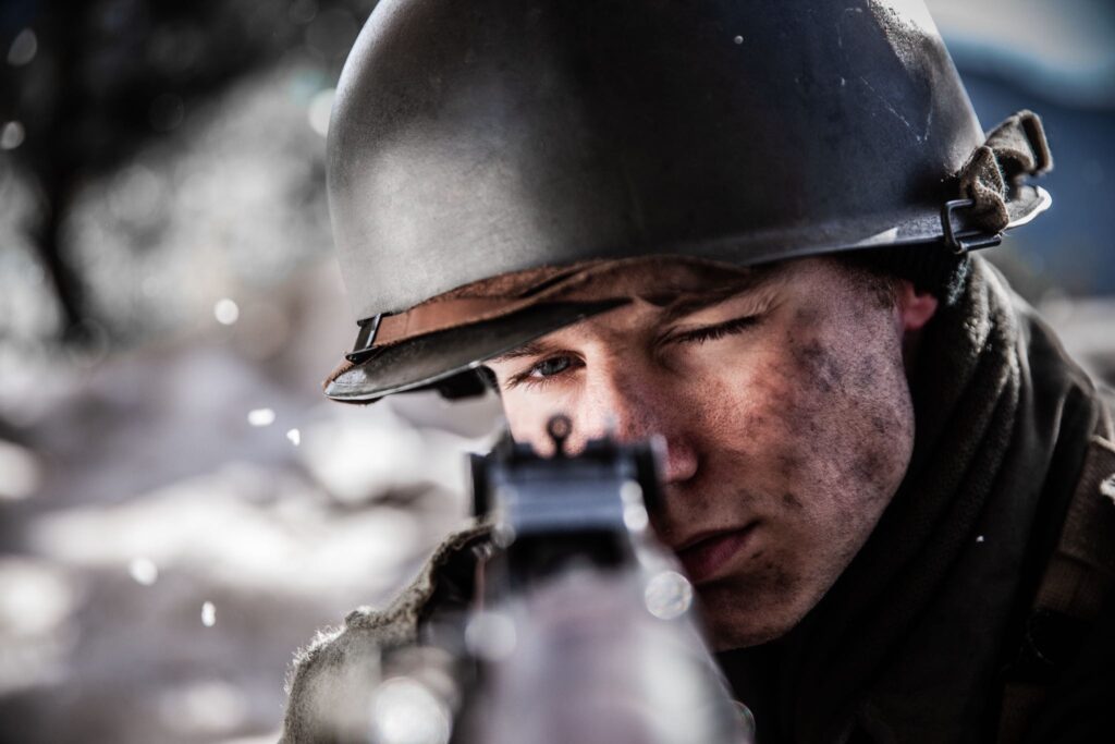 Private First Class Melvin Biddle takes aims with his M1 Garand in the forest outside Hotton. (Dramatic Recreation) Mitch Nel.