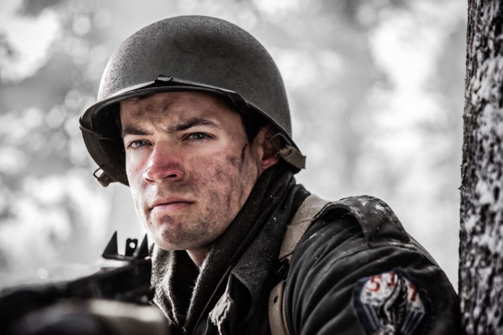 An American Sergeant advances with with his Thompson machine gun through the forest near Hotton, Belgium. (Dramatic Recreation) Joey Mckerricher.