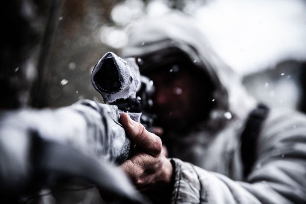 A German sniper in white camouflage, takes aim with his rifles in the forest outside Hotton, Belgium. (Dramatic Recreation) TJ Mathews.