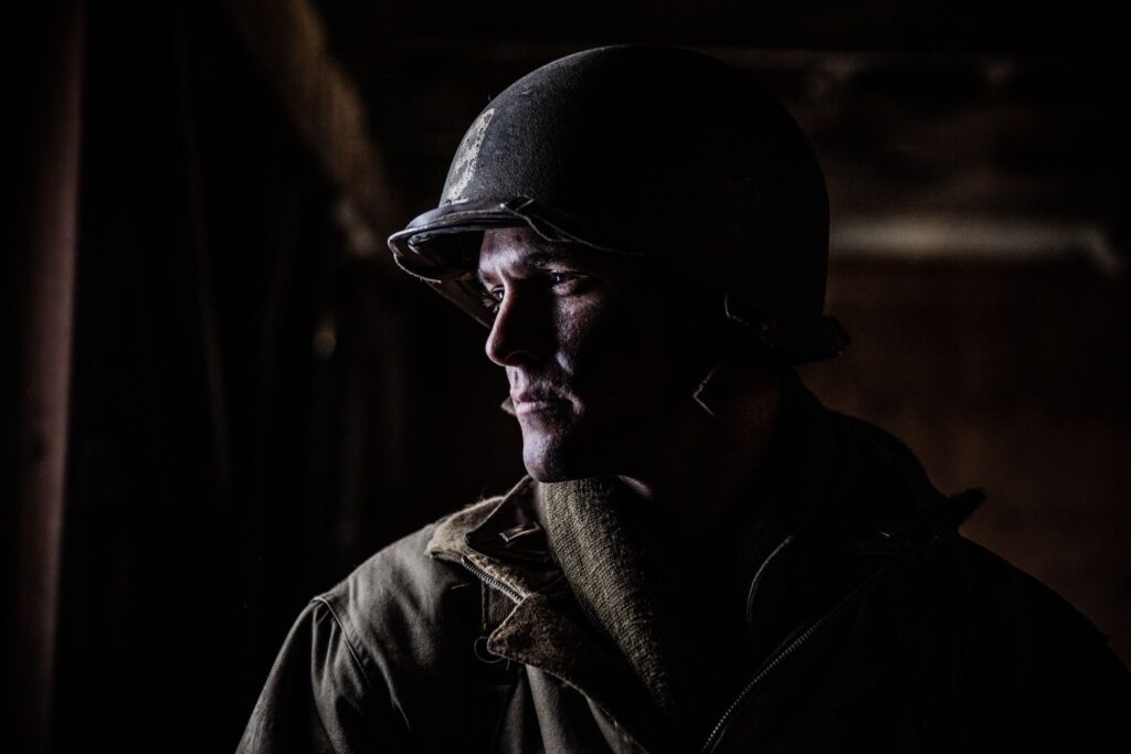 Lieutenant Mike McDonald watches for enemy soldiers from a schoolhouse window north of Hotton, Belgium. (Dramatic Recreation) William Grossman