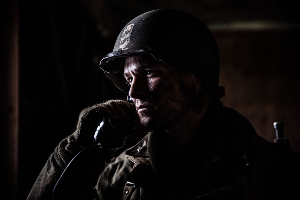 Lieutenant Mike McDonald radios for support from a schoolhouse in the north of Hotton, Belgium. (Dramatic Recreation) William Grossman