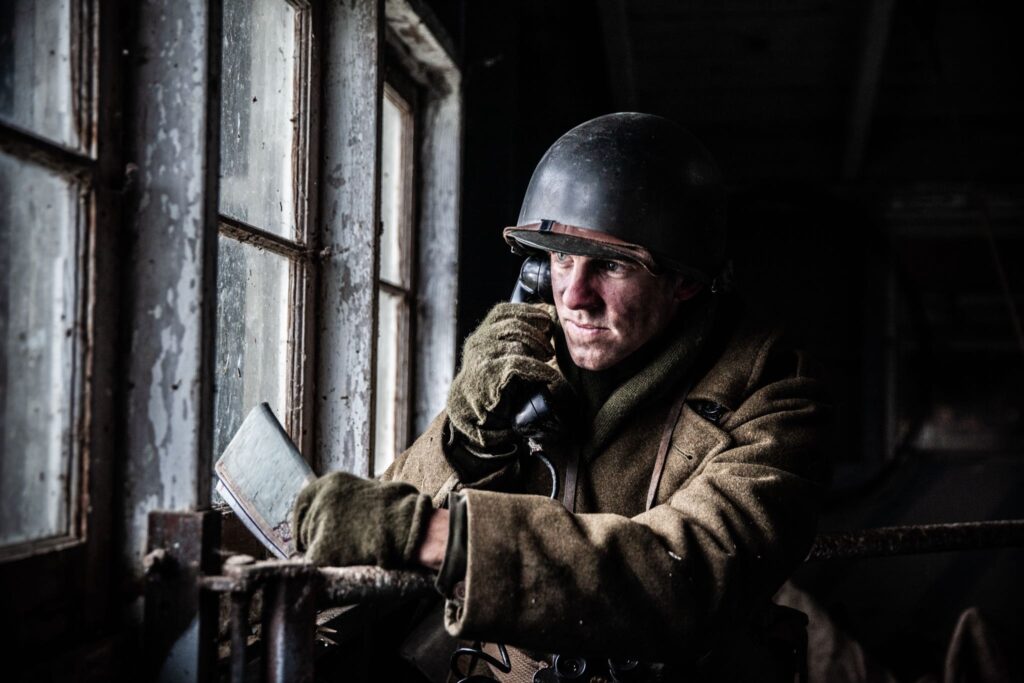 A 242nd Infantry Regiment Artillery Observer calls in artillery from a church steeple in Hatten, France. (Dramatic Recreation). Cole Breckell.