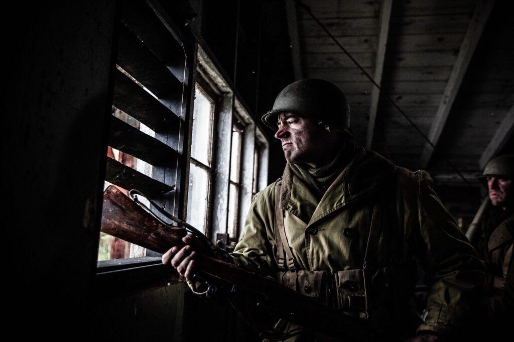 A 242nd Infantry Regiment Soldier breaks the window of the church steeple in Hatten, France. (Dramatic Recreation). Nathan Plumite.