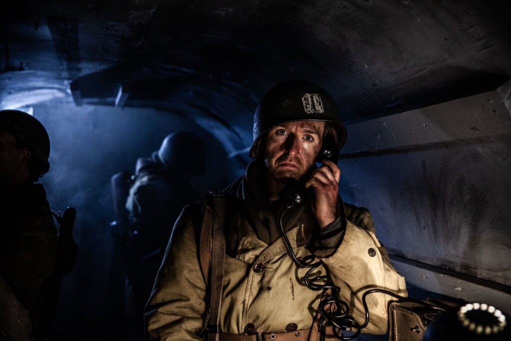 A' Company Commander, Captain William Corson tries to reach his units from his Command Post in Hatten, France. (Dramatic Recreation). Reece Presley.