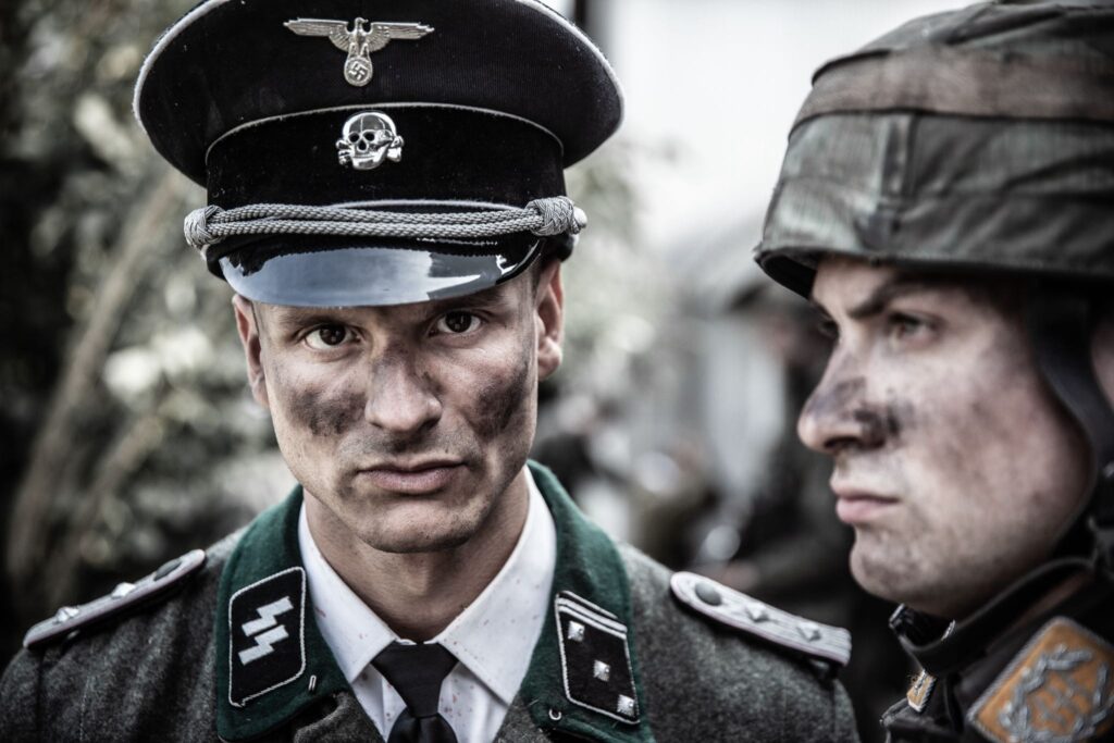 SS Obersturmbannfuhrer Werner Knab interrogates French resistance prisoners captured in Vassieux-en-Vercors. (Dramatic Recreation) (L-R: Alessandro Pekin, Joey Mckerricher)