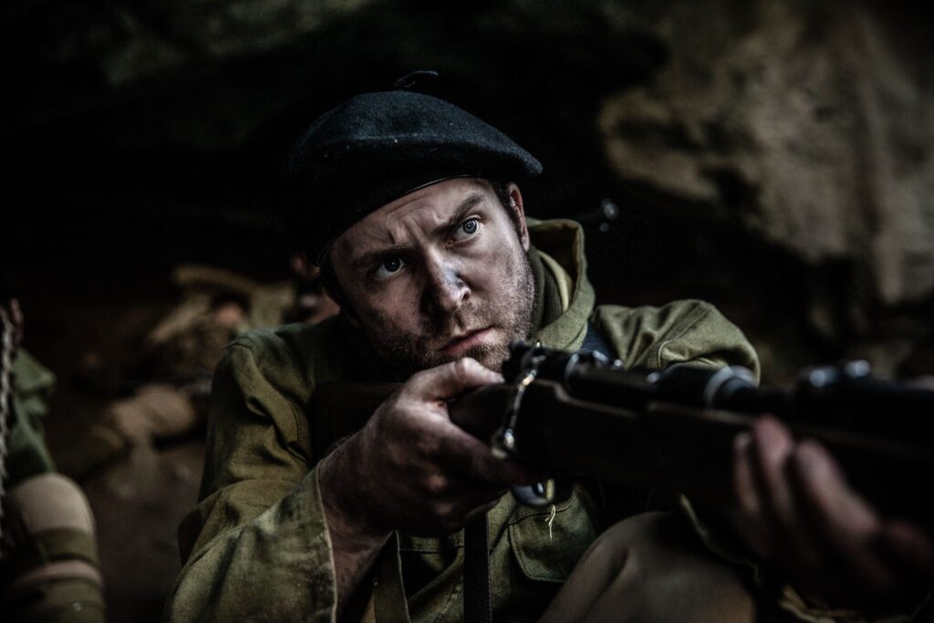 French Maquisard resistance fighter prepares to defend a cave above the Pas de l'Aiguille as German soldiers swarm below. (Dramatic Recreation) (Harrison MacDonald)