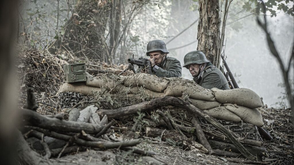 A German machine gun nest targets soldiers of the U.S. 8th Infantry Regiment in the Hurtgen Forest. (Dramatic Recreation) (L-R: Marcel Heim & Joey Mckerricher)